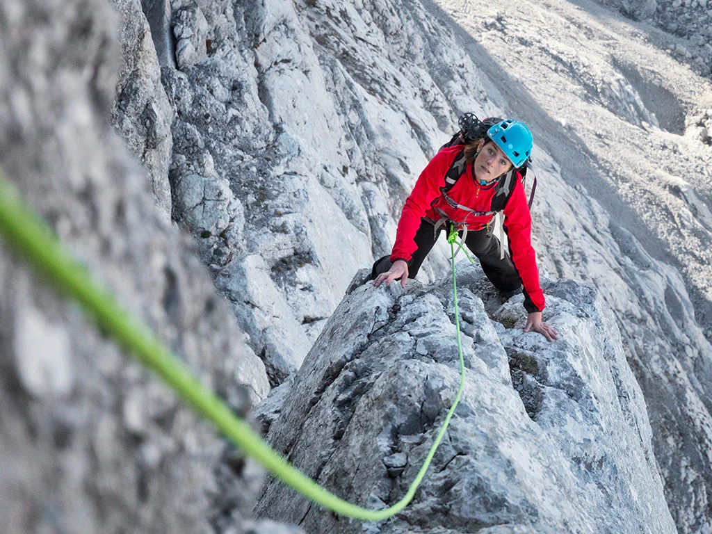 A climber moving up a steep rock route